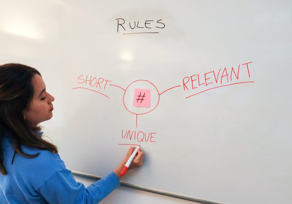 A woman writing on an eraser board about rules.